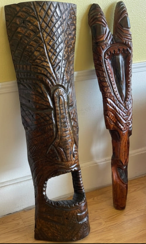 Carved wooden panels with intricate patterns on a wall. carved tiki hawaii gods
