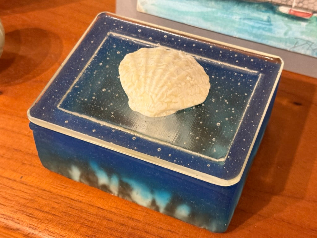 Blue glass container with a textured white object on a wooden surface