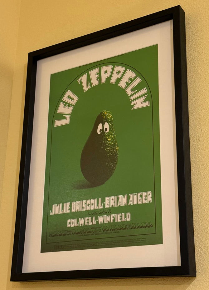 Framed poster of Led Zeppelin with avocado illustration on a beige wall