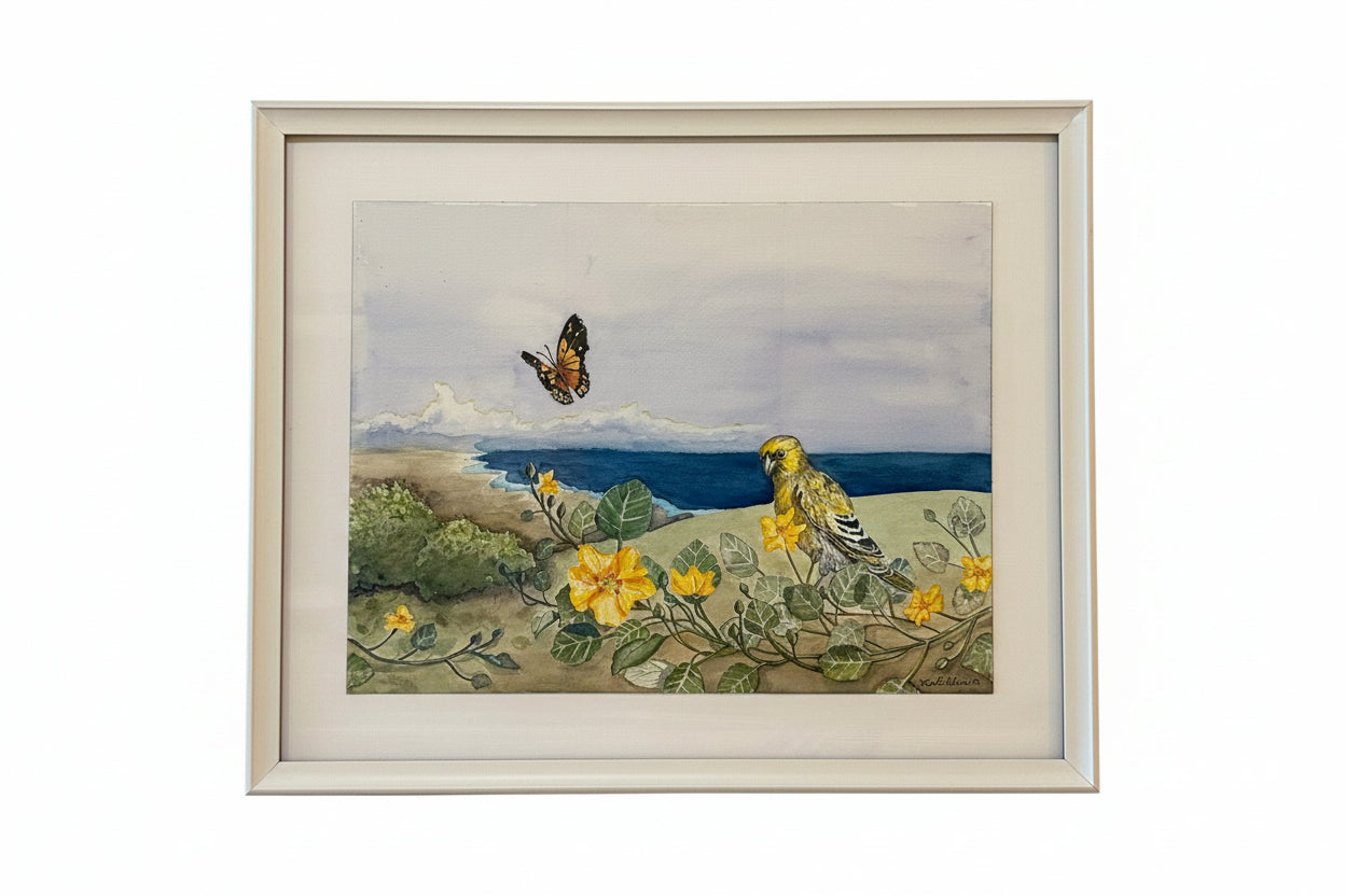 A framed art print depicting a yellow native hawaiian bird perched on yellow flowers by the ocean, with a hawaiian kamehameha butterfly in the sky, set in a light-colored frame against a white background.