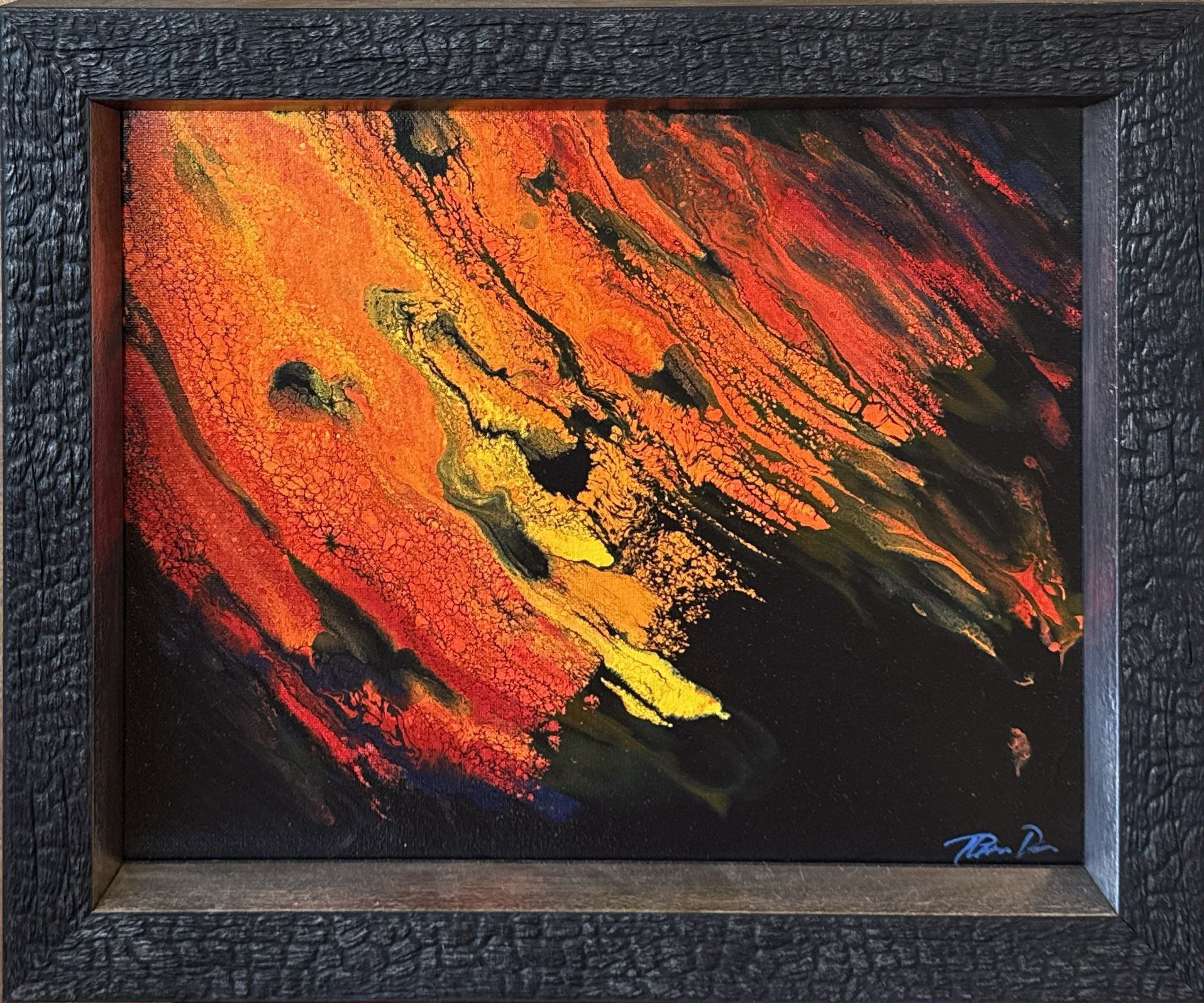 Framed abstract painting with dynamic swirls of orange, red, yellow, and black, set in a textured dark wood frame. lava lavascape kilauea volcano hawaii island art 