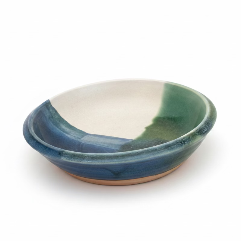 Green ceramic bowl on a beige surface