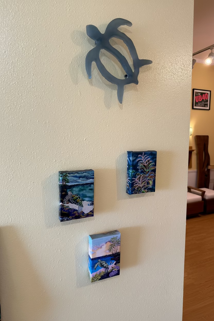 Decorative turtle sculpture and wall art on a textured wall.