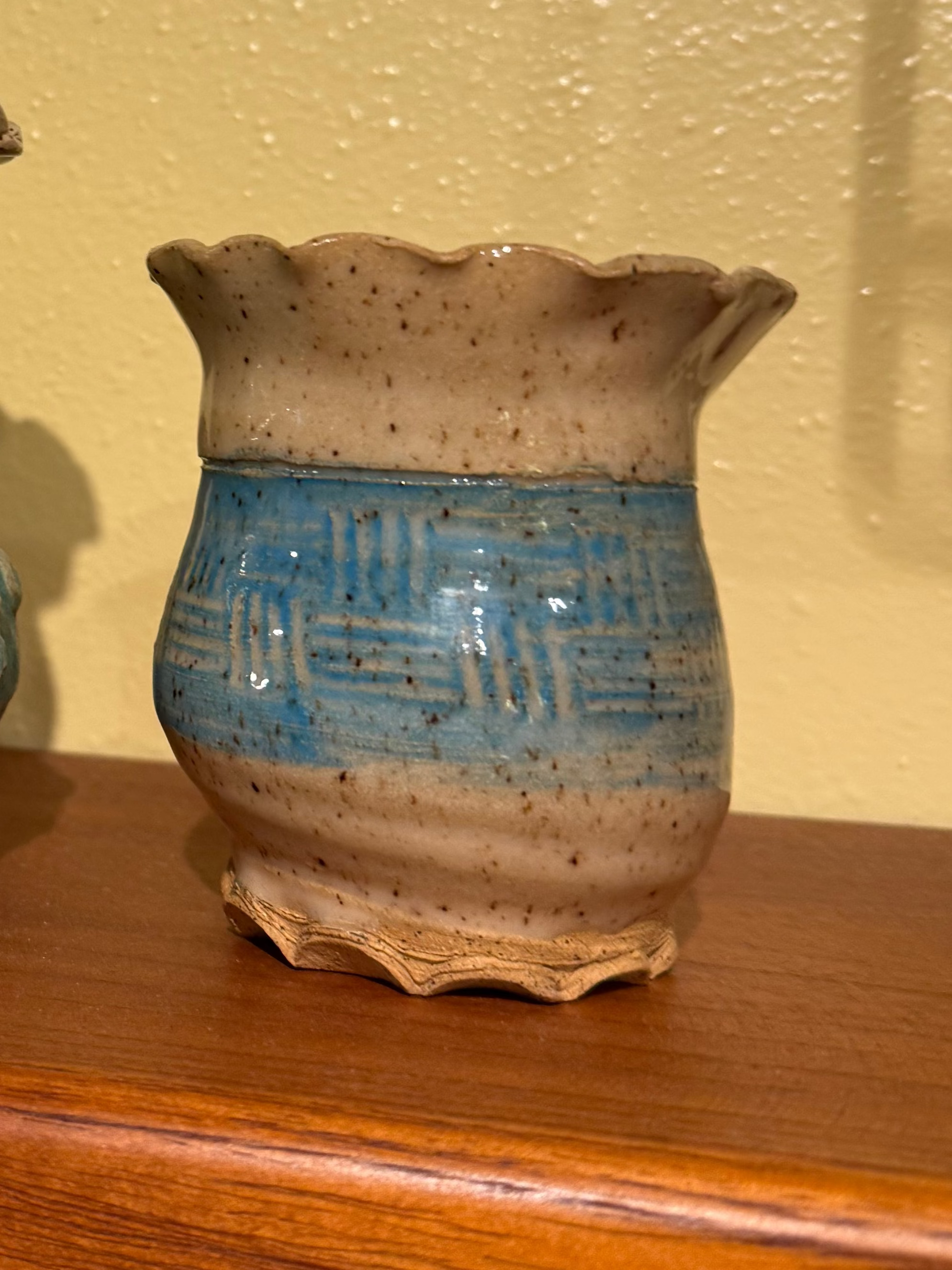 small Ceramic vase with blue and beige design on a wooden surface
