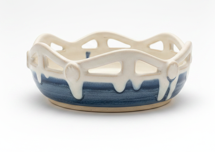 Decorative ceramic dish with blue and white design on a wooden shelf.