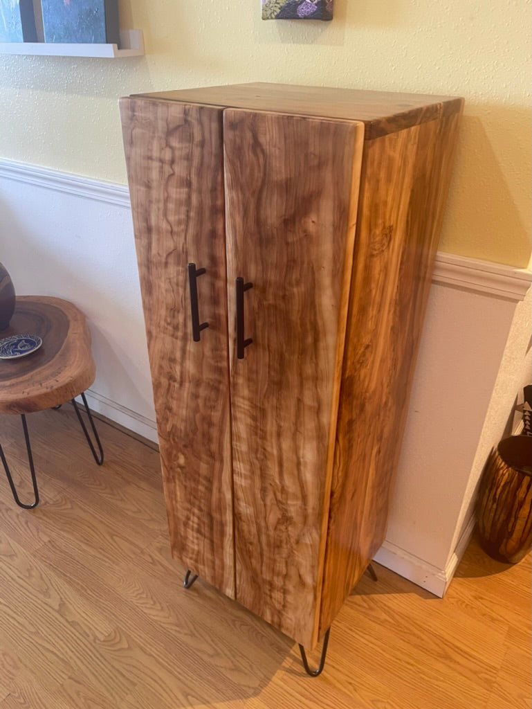 Wooden cabinet with two doors on hairpin legs in a room setting