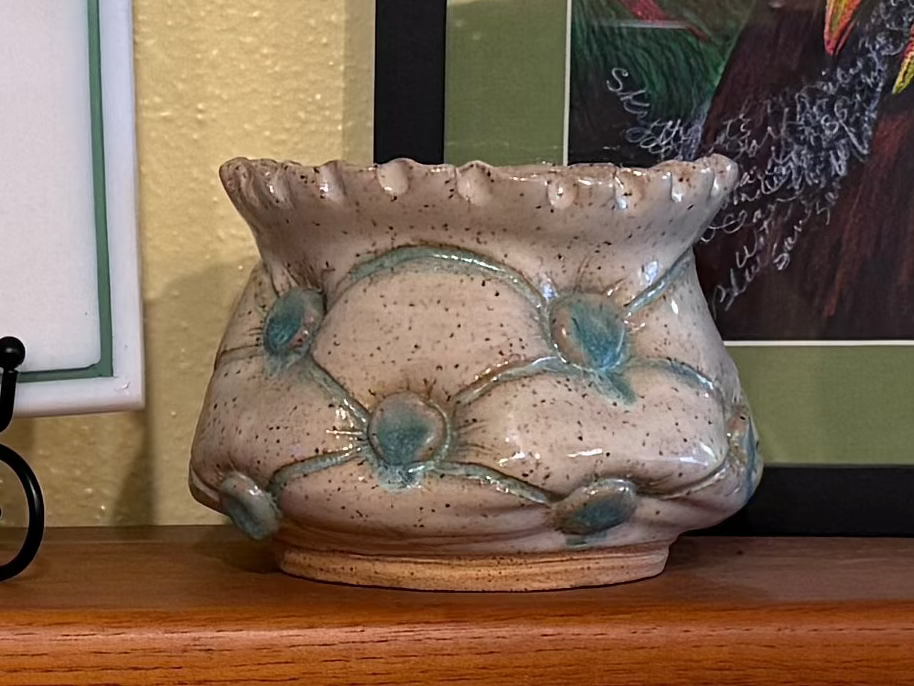Ceramic vase with floral design on a wooden surface