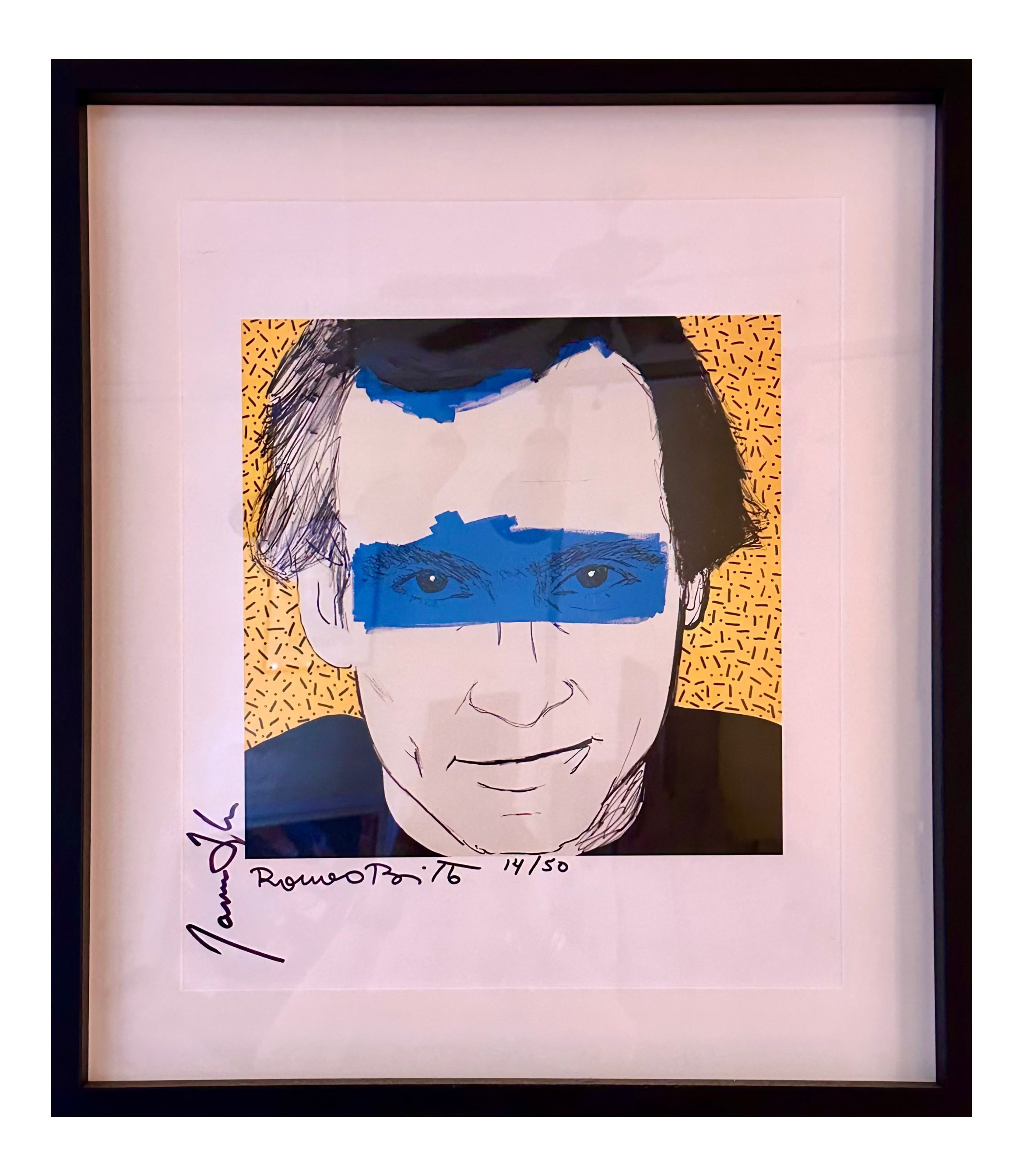 A framed pop art portrait print of James Taylor, signed and numbered 'James Taylor ' on the mat board. The artwork features a stylized face with blue paint over the eyes and hair, set against a yellow patterned background, enclosed in a black frame with a white mat. vintage rock and roll concert poster 