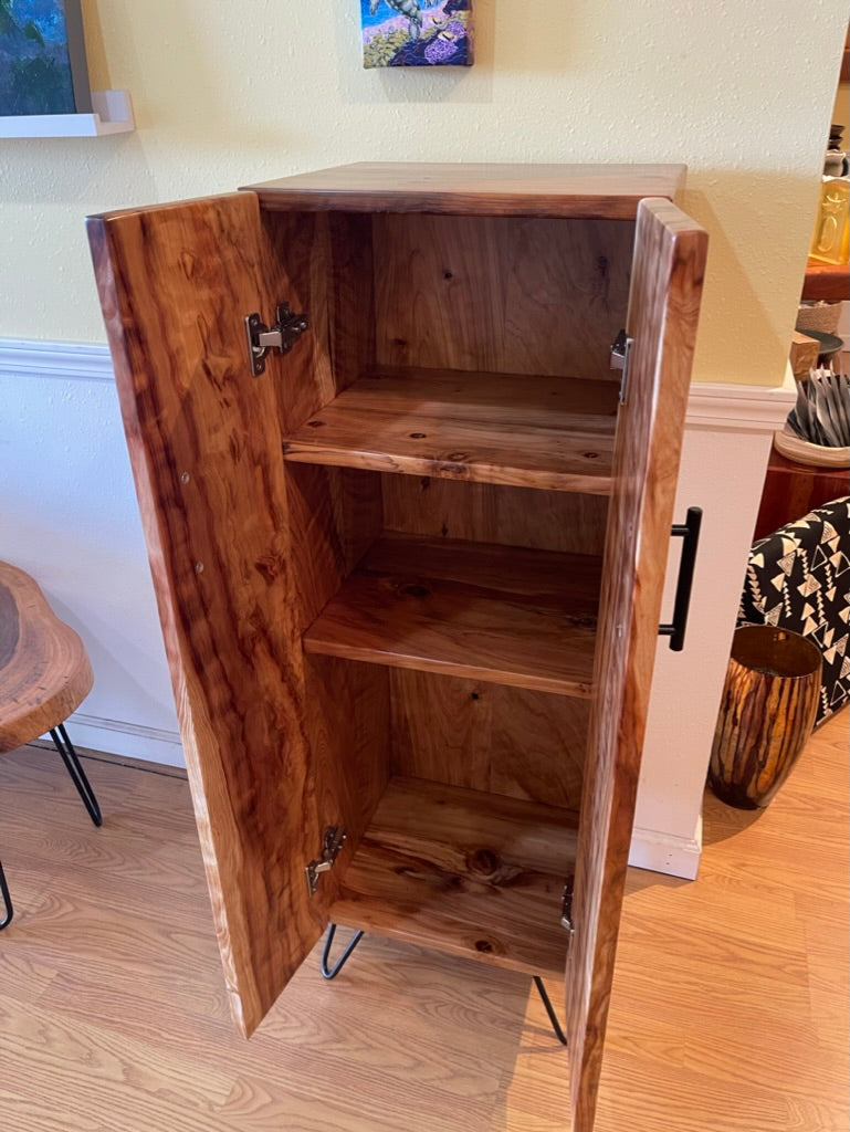 Wooden cabinet with open doors on a wooden floor